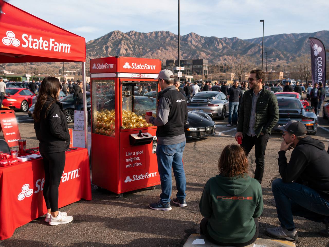 State Farm branded Drop Zone unit at outdoor car show with mountains